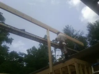 Carpenter setting a ridge beam over a new addition frame — Ice Dam Removal by Roofing Brothers in Lincolnwood