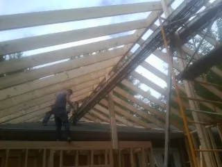 Rafters going up over a new addition with a worker on the wall in Lincolnwood