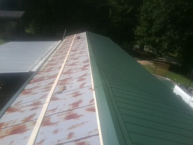 Old rusted panels beside newly installed green metal roofing — Wind Damage Roof Repair by Roofing Brothers in Lincolnwood