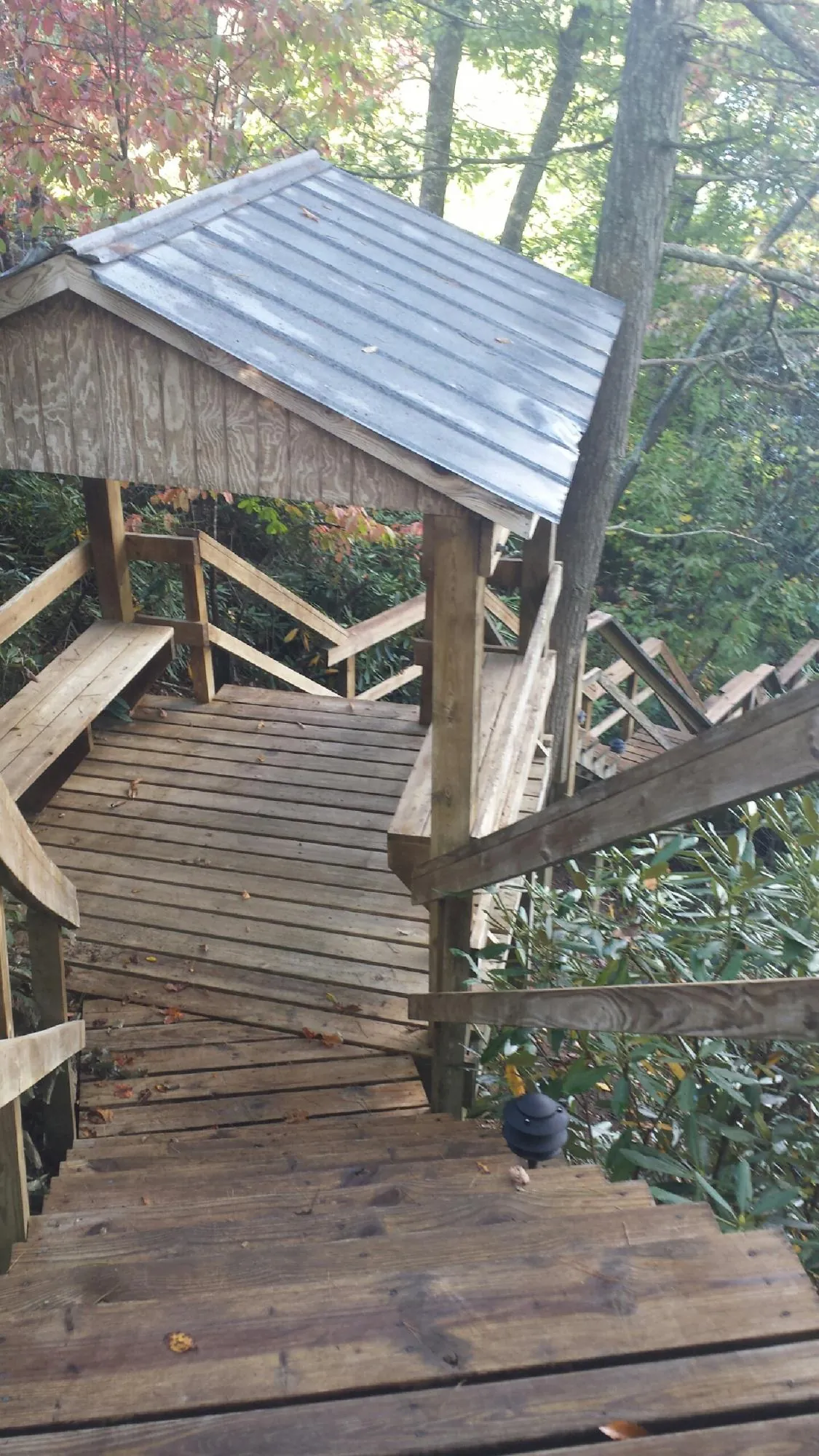 Metal roofed shelter over wooden steps on a wooded walkway — Skylight Repair & Installation work by our crew in Lincolnwood
